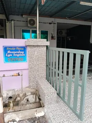 a entrance to a house with a fence and a sign at Homestay Lyn Impian in Tanjung Rambutan