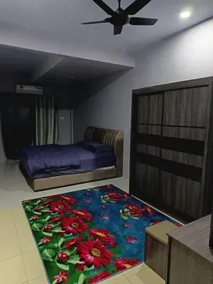a bedroom with a bed and a flower rug at Homestay Lyn Impian in Tanjung Rambutan