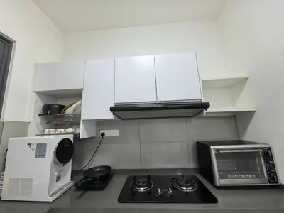 a kitchen with a stove top oven and a microwave at Royal Comfort Suite Meritus near swimming pool in Perai
