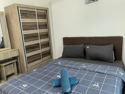 a bedroom with a bed with a blue pillow on it at Royal Comfort Suite Meritus near swimming pool in Perai