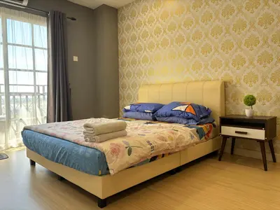 a bedroom with a bed with blue pillows and a table at KF Homestay Premium Suite in Kampar
