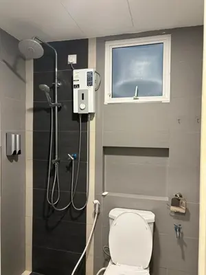 a bathroom with a shower with a toilet and a window at KF Homestay Premium Suite in Kampar