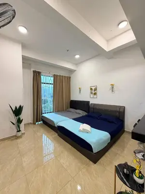 a bedroom with a large bed with blue sheets at D'Anggun Studio in Gua Musang