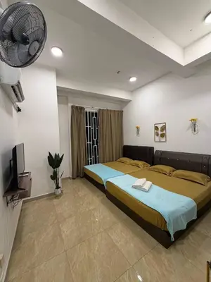 a large bedroom with two beds and a fan at D'Anggun Studio in Gua Musang