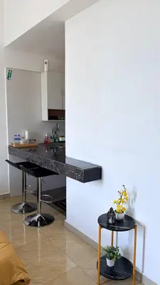 a kitchen with a black counter top in a room at D'Anggun Studio in Gua Musang