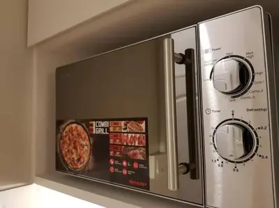 a microwave oven with a pizza inside of it at Heritage Loft on Beach Street near UNESCO Zone & Street Art 2 in George Town