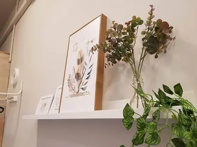 a shelf with pictures and a vase with flowers on it at Heritage Loft on Beach Street near UNESCO Zone & Street Art 2 in George Town