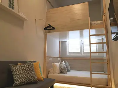 a room with a bunk bed with a couch and a ladder at Heritage Loft on Beach Street near UNESCO Zone & Street Art 3 in George Town