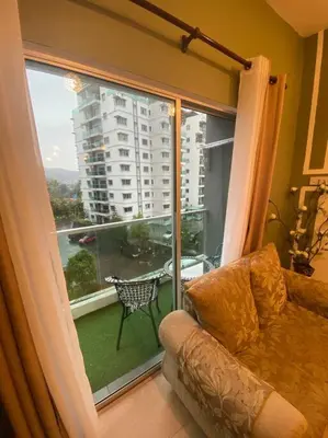 a living room with a couch and a large window at Nature's Sanctuary at Tanah Rata in Tanah Rata