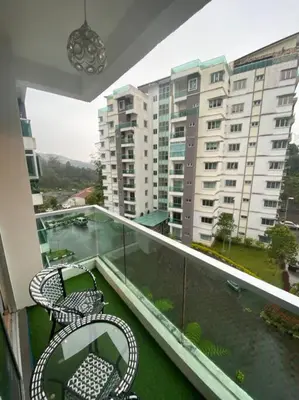 a balcony with two chairs and a table and a building at Nature's Sanctuary at Tanah Rata in Tanah Rata