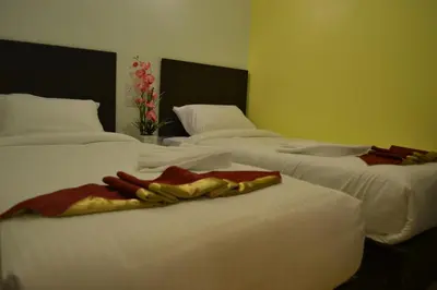 a group of three beds in a room at DR Hotel Penang in Bayan Lepas