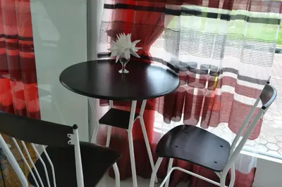 a table with two chairs in front of a window at DR Hotel Penang in Bayan Lepas