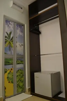 a room with a sliding glass door with a picture of a beach at DR Hotel Penang in Bayan Lepas