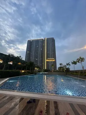 a large swimming pool in front of a tall building at Mini Studio in Batu Kawan in Batu Kawan
