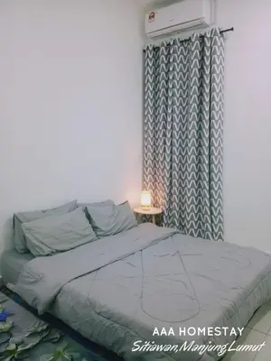 a bedroom with a bed and a window with a heater at AAA homestay in Sitiawan