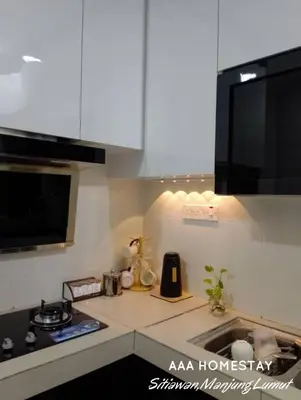 a kitchen with white cabinets and a counter top at AAA homestay in Sitiawan