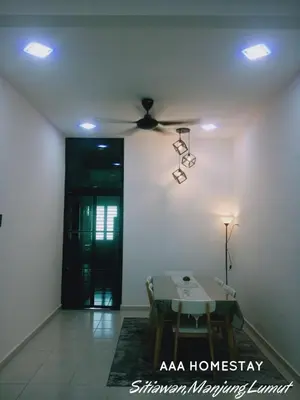 a living room with a ceiling fan and a table at AAA homestay in Sitiawan