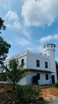 a white building with a lighthouse on top of it at Pearl Castlestay in Tanjung Karang