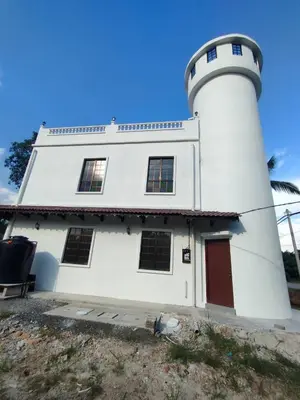 a lighthouse sitting next to a white building at Pearl Castlestay in Tanjung Karang