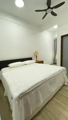 a bedroom with a white bed with a ceiling fan at Pearl Castlestay in Tanjung Karang