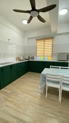 a kitchen with green cabinets and a ceiling fan at Pearl Castlestay in Tanjung Karang