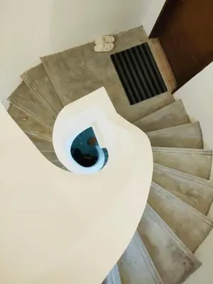 a white toilet in a room with stairs at Pearl Castlestay in Tanjung Karang