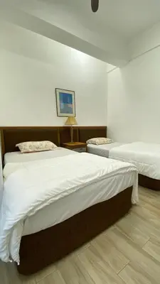 a bedroom with two beds and a table at Pearl Castlestay in Tanjung Karang