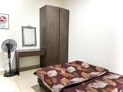 a bedroom with a bed and a cabinet and a fan at Ammara Homestay 3 Palas horizon Kea Farm in Cameron Highlands