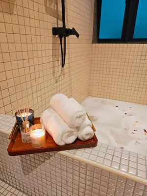 a tray with towels and candles on a bath tub at The Palm Suite at Lava Mansion in George Town