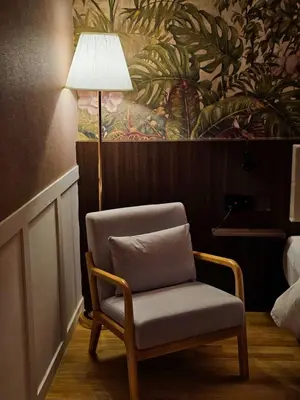 a chair in a hotel room with a lamp at The Palm Suite at Lava Mansion in George Town