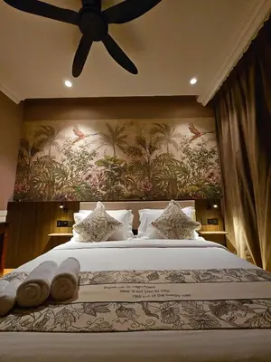 a bedroom with a large bed with a painting on the wall at The Palm Suite at Lava Mansion in George Town