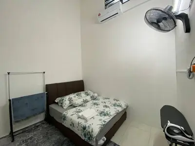 a small bedroom with a bed and a fan at Rumah teres untuk keluarga in Tanjung Rambutan