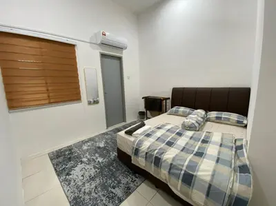 a bedroom with a bed with a checkered blanket at Rumah teres untuk keluarga in Tanjung Rambutan