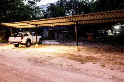 a white suv parked under a shed on the side of a road at Value Inn Homestay by uBook in Butterworth