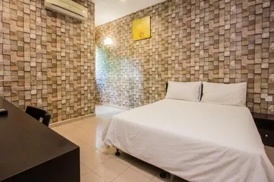a bedroom with a bed and a brick wall at Value Inn Homestay by uBook in Butterworth