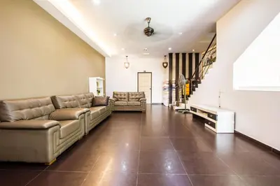 a living room with couches and a staircase at Value Inn Homestay by uBook in Butterworth