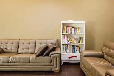 a living room with a couch and a book shelf at Value Inn Homestay by uBook in Butterworth