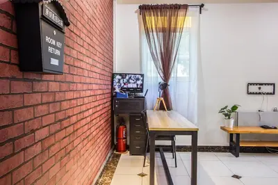 a room with a brick wall and a table and a window at Surprised Homestay by uBook in Butterworth