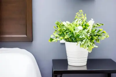 a white vase with flowers on a table at Surprised Homestay by uBook in Butterworth