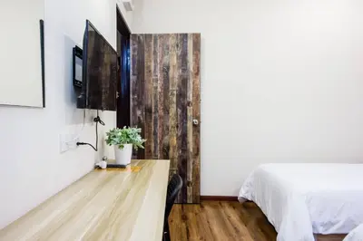 a bedroom with a bed and a tv on a wall at Surprised Homestay by uBook in Butterworth