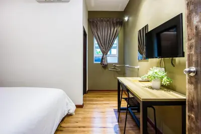 a bedroom with a bed and a desk with a tv at Surprised Homestay by uBook in Butterworth