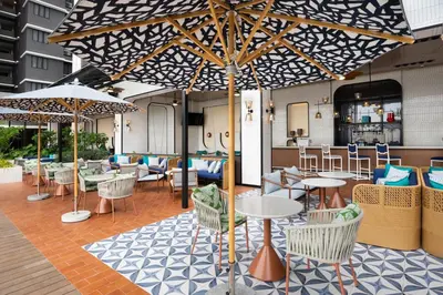 a restaurant with tables and chairs and umbrellas at Iconic Marjorie Hotel, Penang, a Tribute Portfolio Hotel in Bayan Lepas