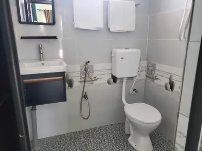 a white bathroom with a toilet and a sink at Inap Desa Fajar Saujana in Baling