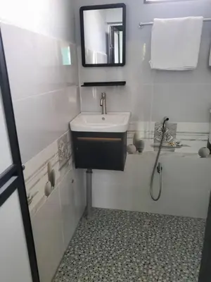 a white bathroom with a sink and a shower at Inap Desa Fajar Saujana in Baling