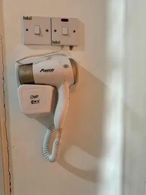 a hair dryer is hanging on a wall at AYAAN SERENE BUDGET HOMESTAY with FREE WiFi and Netflix in Tanah Rata