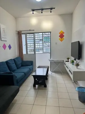 a living room with a blue couch and a tv at AYAAN SERENE BUDGET HOMESTAY with FREE WiFi and Netflix in Tanah Rata