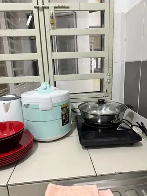 a kitchen counter with a stove with a pan on it at AYAAN SERENE BUDGET HOMESTAY with FREE WiFi and Netflix in Tanah Rata
