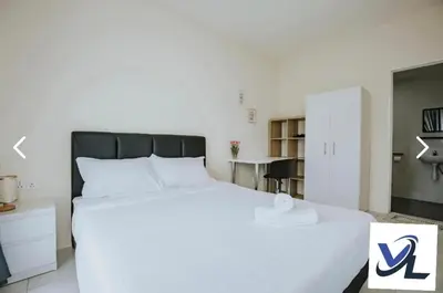 a bedroom with a white bed with a black headboard at anderson condo in Ipoh
