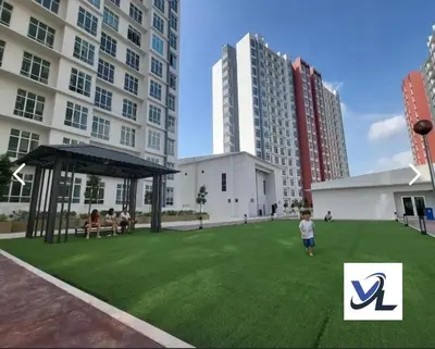 a child standing in a field of grass in front of a building at anderson condo in Ipoh