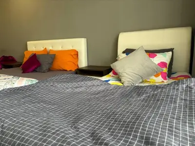a bedroom with a large bed with colorful pillows at KF Homestay Double Suite in Kampar
